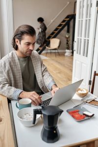 man with laptop having breakfast