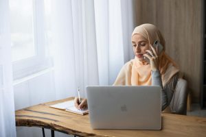 confident ethnic female working at home